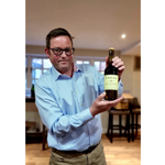 Islay Distiller David Wood holding a bottle of single malt whiskey.