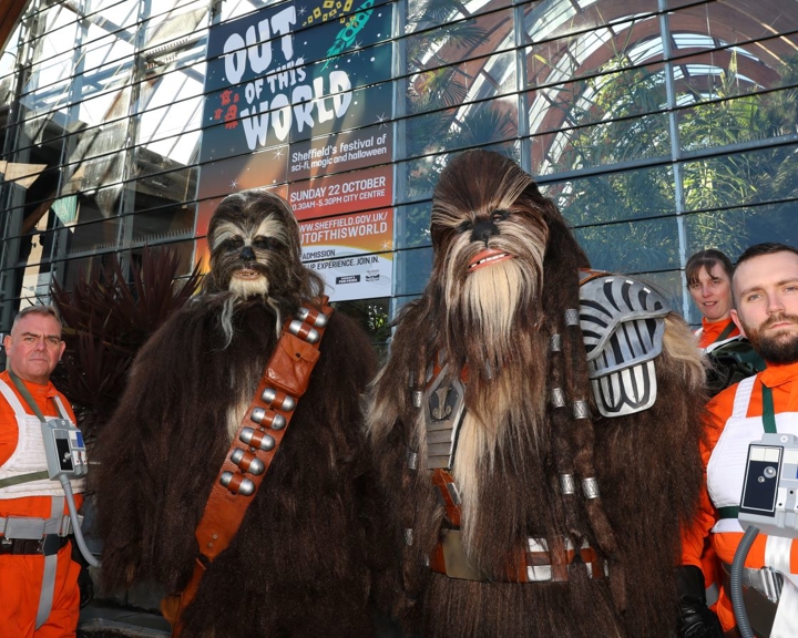 Two wookies and three Rebel Fighter Pilots, from Star Wars, stand outside Sheffield Winter Garden.