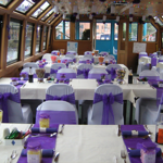 Inside the A&G Passenger Boat, with rows of tables set up for dining.