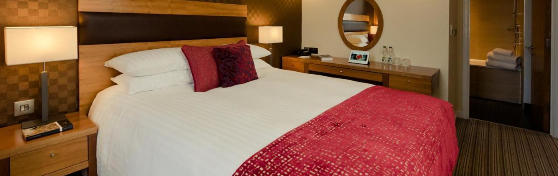 Bedroom at the Leopold Hotel with double bed and soft furnishings.