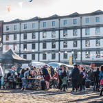 Victoria Warehouse building with market stalls laid out along the cobbles in front 