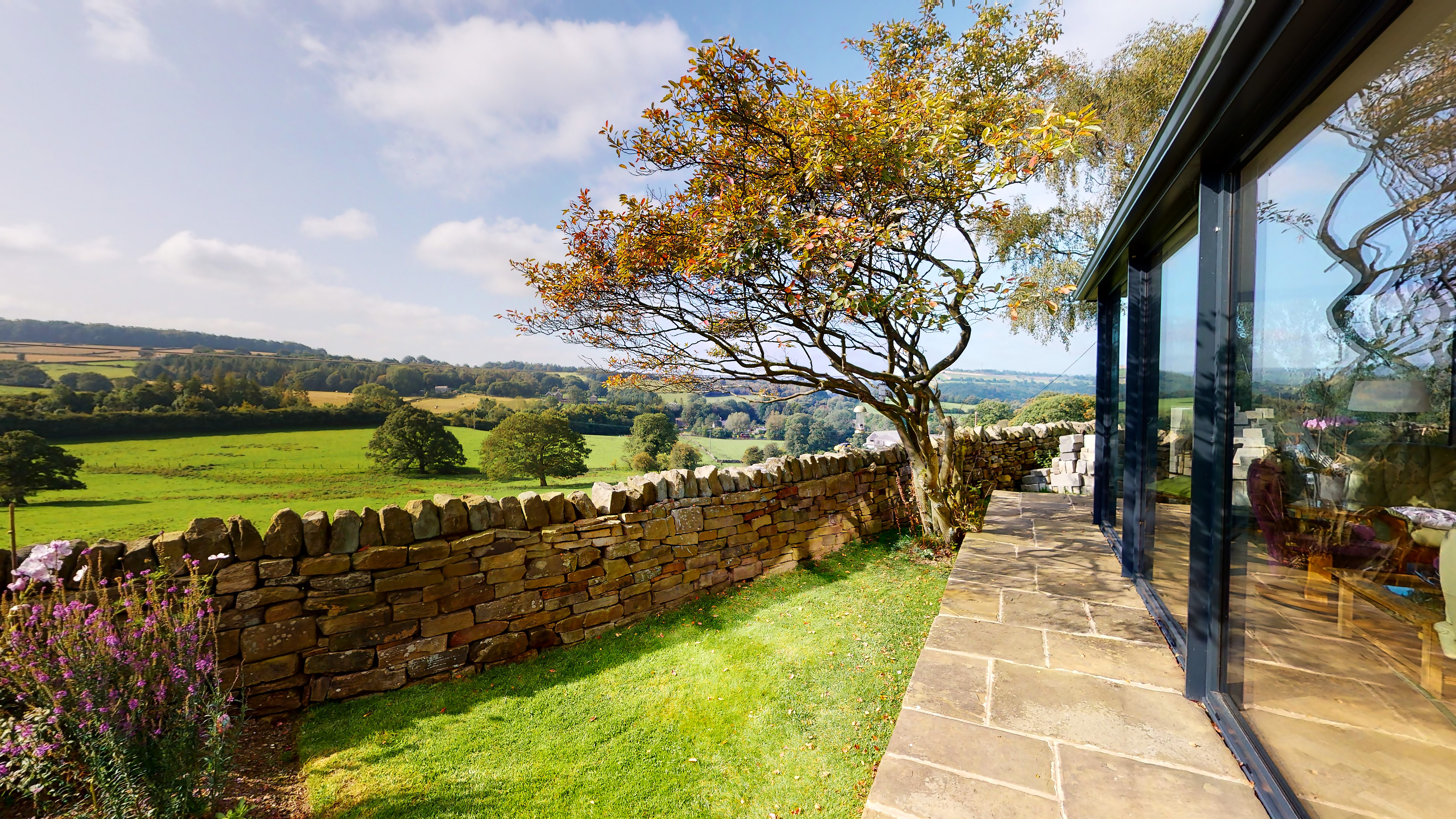 Scenic view of open countryside with rolling fields and distant trees.