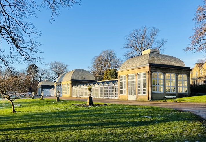 The Sheffield Botanical Gardens glass house on a sunny day.