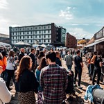 Walking behind a crowd of people as they peruse stalls at Quayside Market on a sunny day