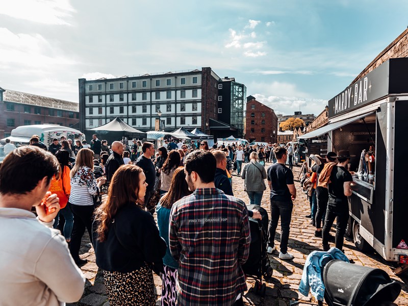 Walking behind a crowd of people as they peruse stalls at Quayside Market on a sunny day