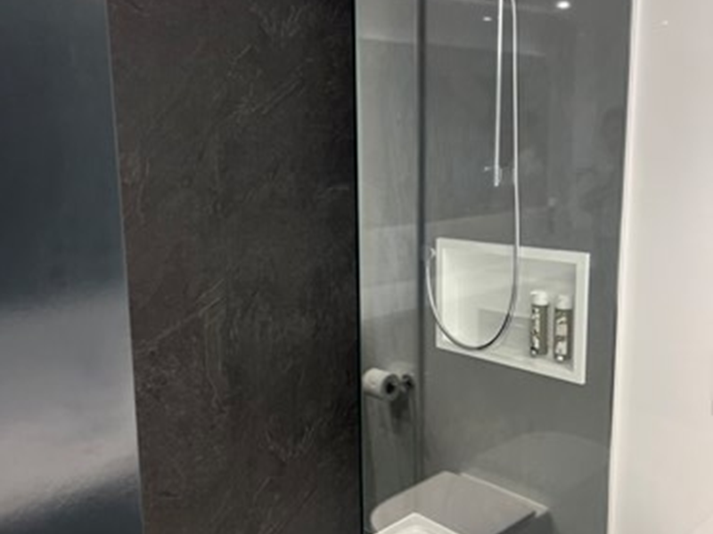 Bathroom with a large shower and a glass partition.