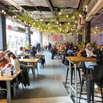 Inside Sheffield Plate, a bright an airy foodhall in Sheffield . There are lots of people sat at tables eating and chatting.