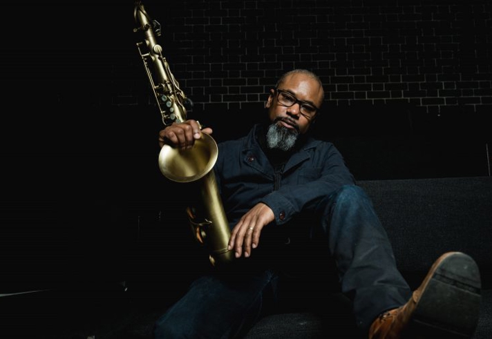 Denys Baptiste posing with his saxaphone.