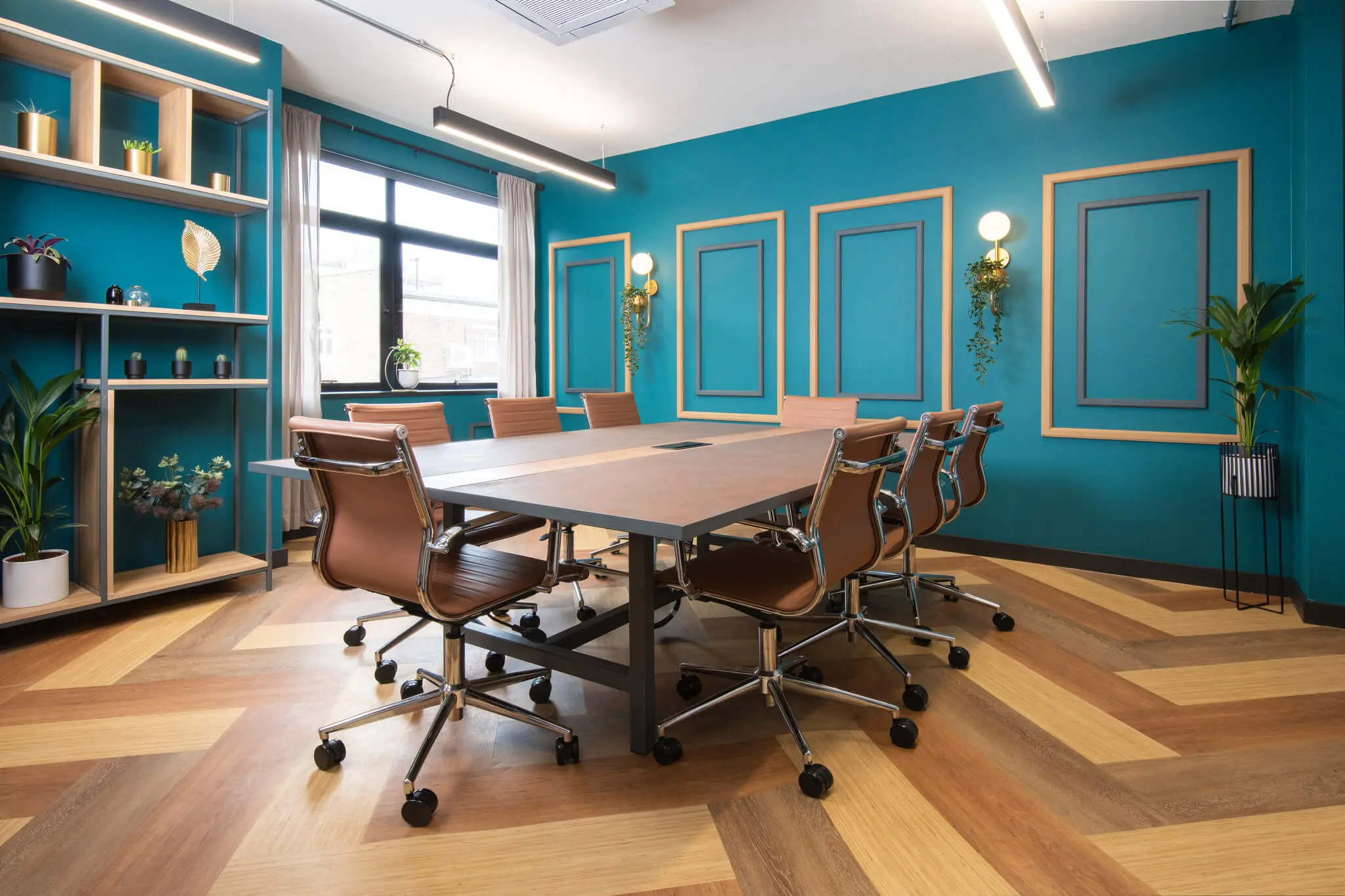A smartly decorated room with a large table, in the centre, surrounded by office chairs.