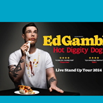 A promo poster for Ed Gamble - Hot Diggity Dog.  Ed Gamble is sat at a table on which sits a half-eaten hot dog covered in ketchup and mustard. Ed is wearing a white t-shirt which has lots of ketchup and mustard spilt down the front.  His face is also covered in Ketchup and mustard and he gently dabbing at it with a white napkin.