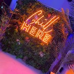 An orange neon sign that reads 'Chill here', on the wall at Sheffield Plate.