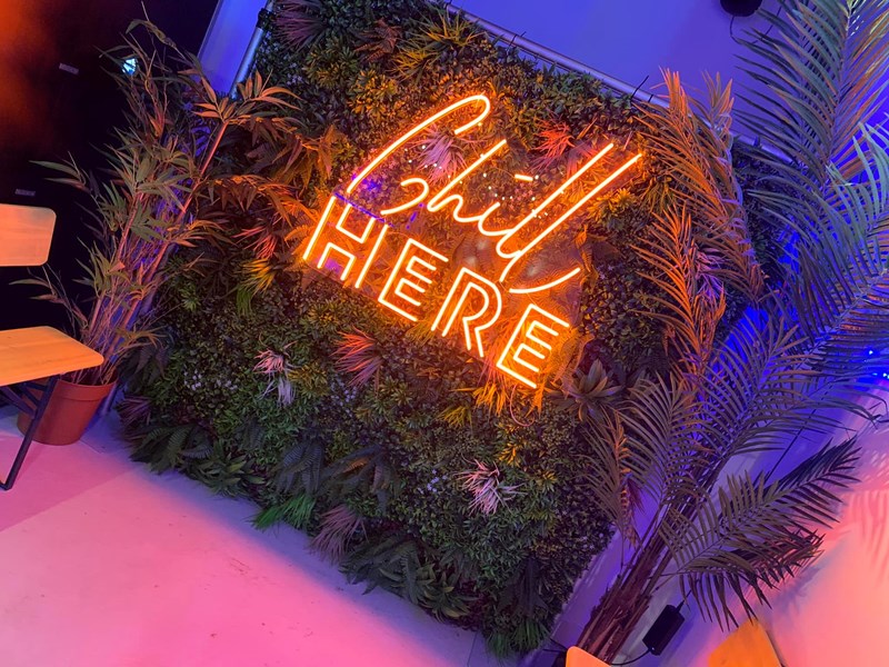An orange neon sign that reads 'Chill here', on the wall at Sheffield Plate.