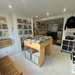 Inside a cosy record shop you can see racks of vinyl and records displayed on the wall. The shop decor is white and minimalist.