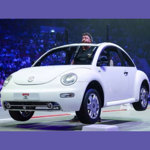 A man lifts up a car in front of an Arena crowd - Britain's Strongest Man 2027