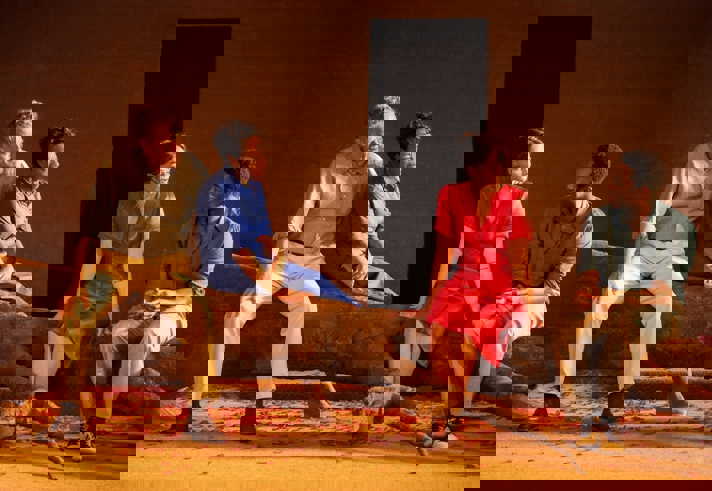 Four actors performing on a stage.