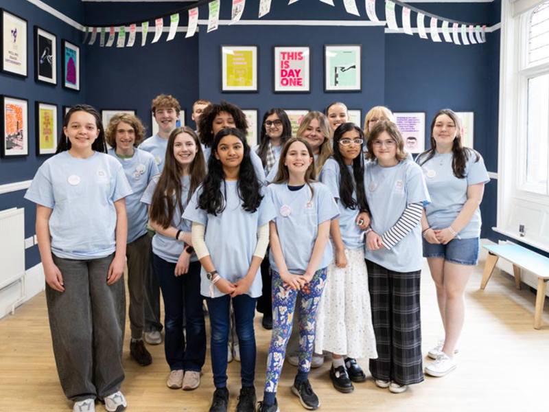 A group of young people standing in the middle of an art exhibition.