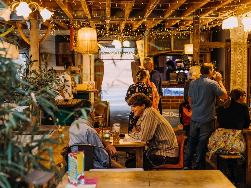 The inside of Hagglers Corner, where people are sat at tales dining.