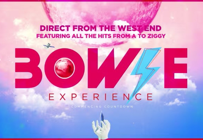 Promotional poster for “Bowie Experience.” The design features bold pink text with a blue lightning bolt in the word “Bowie.” Above, the tagline reads: “Direct from the West End – Featuring all the hits from A to Ziggy.” The background shows a surreal pink planet in a purple sky with clouds, and a hand pointing upward at the bottom.
