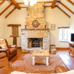 Comfortable living room in a Sykes Holiday Cottage with sofa and television.