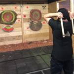  A person throwing two axes at targets in Battle Axe Sheffield.