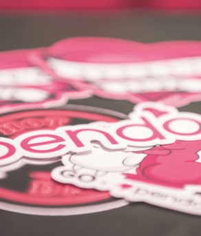 A close up of a dark surface covered in Pendo branded stickers.