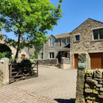 Exterior view of The Clough, a traditional building set in a scenic rural area.