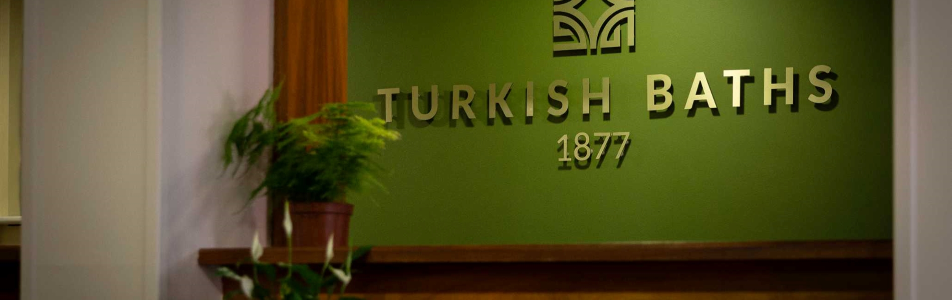 Spa 1877 sign on a wall with plants