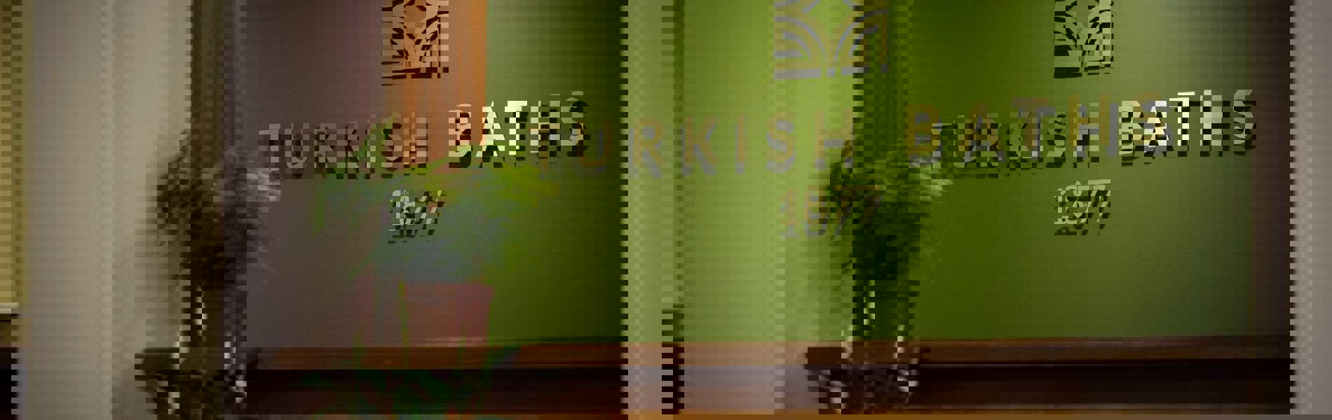 Spa 1877 sign on a wall with plants 