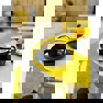 A cappuccino sit on a bright yellow metal table, outside.