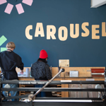 Two people standing, working at a bench in a print studio.