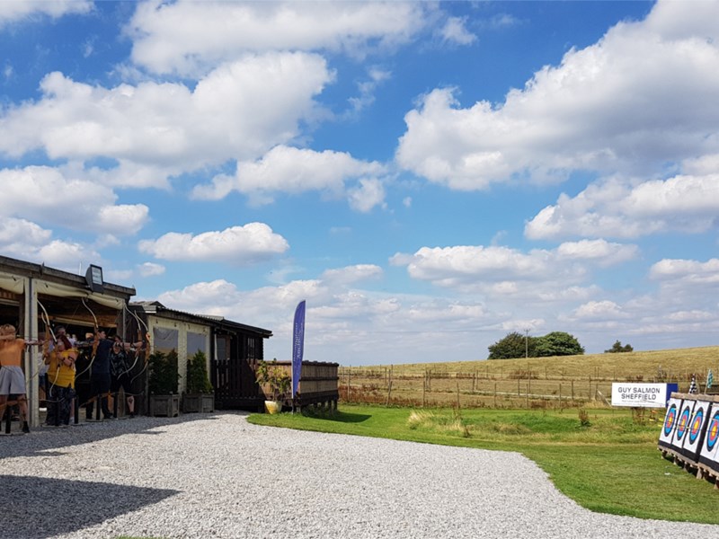 A row of people practising archery.