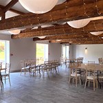 A light and airy room set up with several tables with chairs at Manor Oaks House.