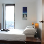 Modern bedroom at Homely Serviced Apartments – St. Paul’s with double bed, wardrobe, and large window providing natural light.