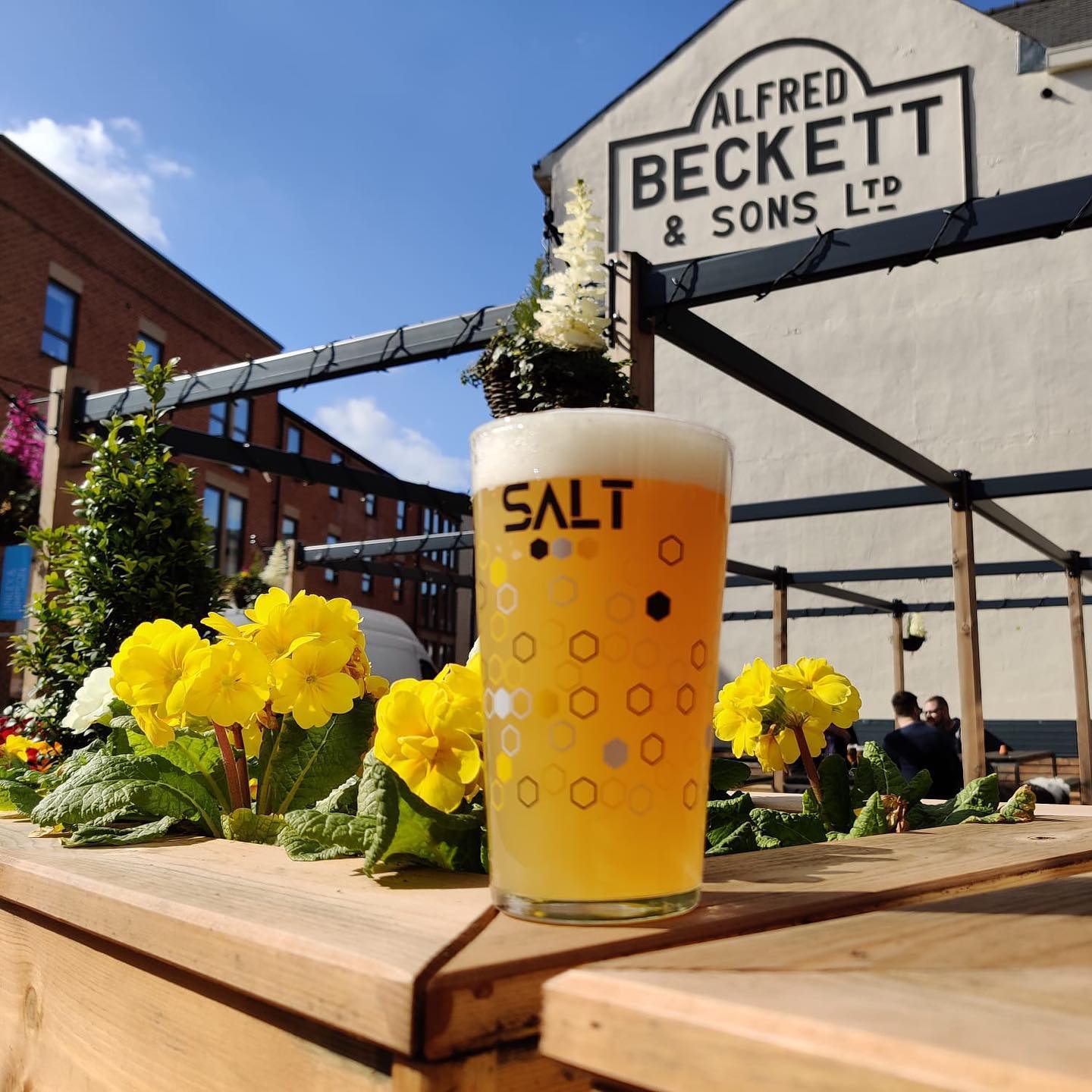 A glass of beer on a table in the beer garden at SALT Sheffield.