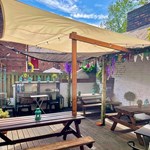 Outdoor courtyard with seating at The Gin Bar at Vintedge .