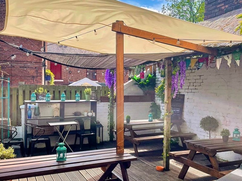 Outdoor courtyard with seating at The Gin Bar at Vintedge .