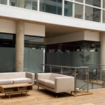An interior shot of Cubo featuring 3 cream sofas and a low, wooden coffee table.