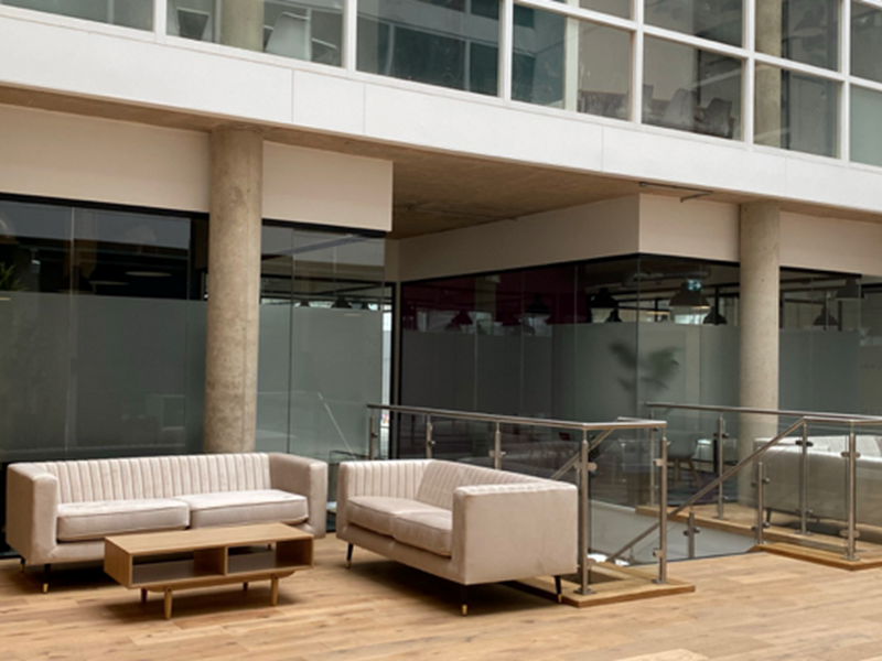 An interior shot of Cubo featuring 3 cream sofas and a low, wooden coffee table.