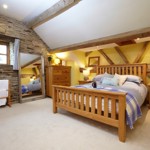 Bedroom at Smallshaw Cottages & Spa featuring a double bed with crisp linens, bedside tables, and soft ambient lighting.