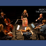 A string quintet performs on stage with a singer.