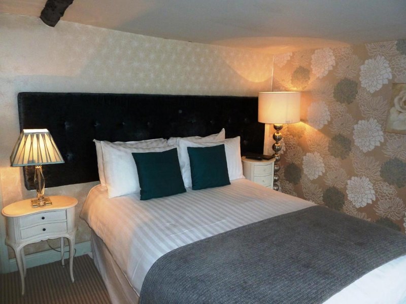 Spacious double bedroom with a large bed, ample floor space, bedside tables.