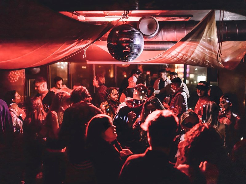 Disco ball above people dancing at Panke Social
