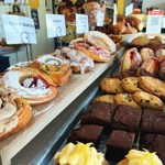 A counter full of cakes and pastries.