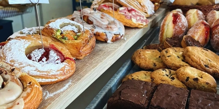A counter full of cakes and pastries.