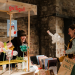 A woman browsing at a stall, chatting with the stall holder.