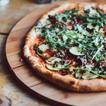 A pizza on a wooden board.