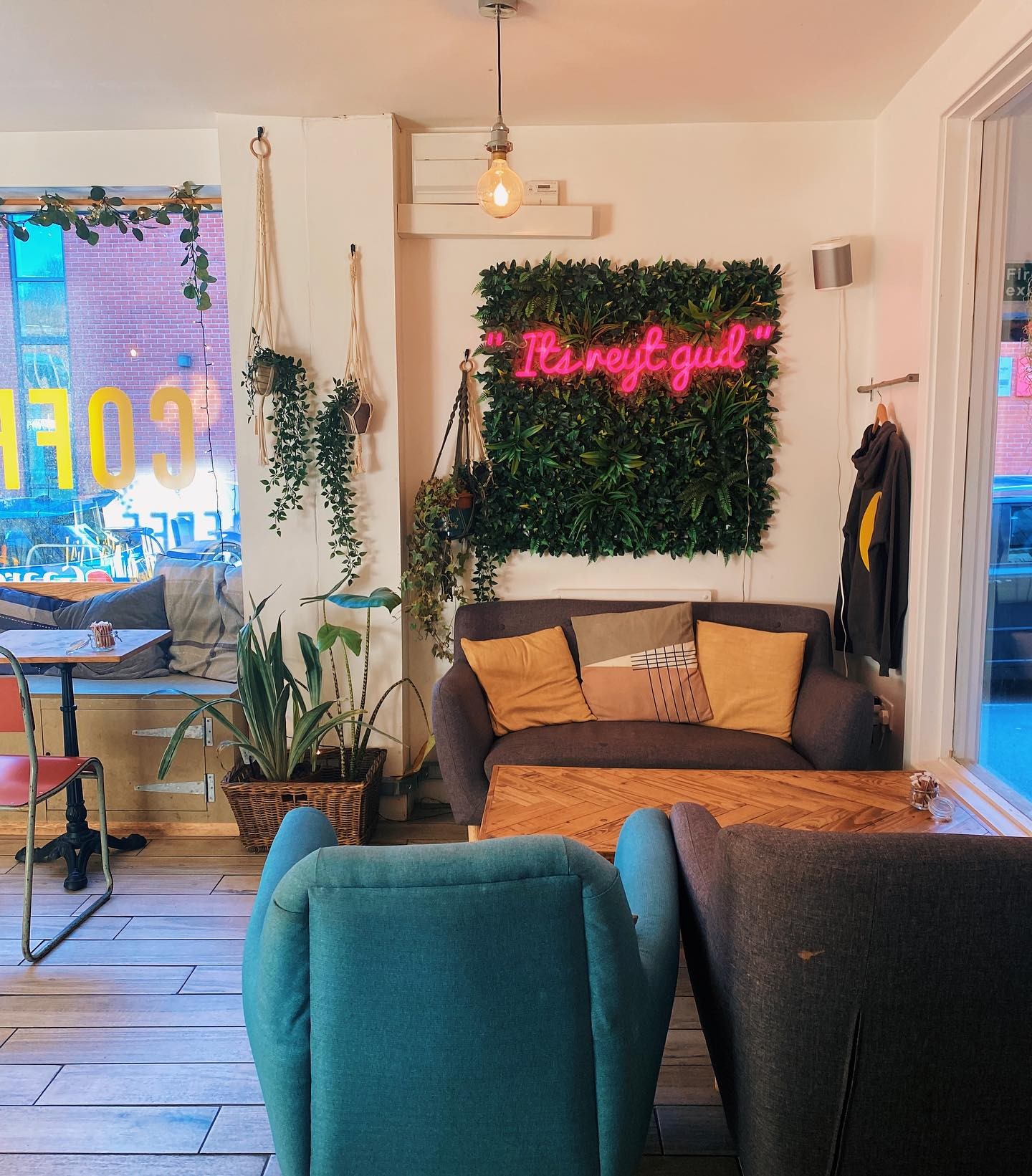 Two armchairs and a sofa on either side of a low table at Gaard Coffee Hide.