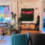 Two armchairs and a sofa on either side of a low table at Gaard Coffee Hide.