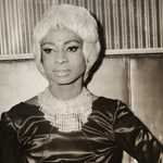 A black and white photo of a person in a glamorous dress and necklace.