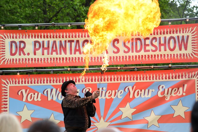 Fire breather in bowler hat performing on stage